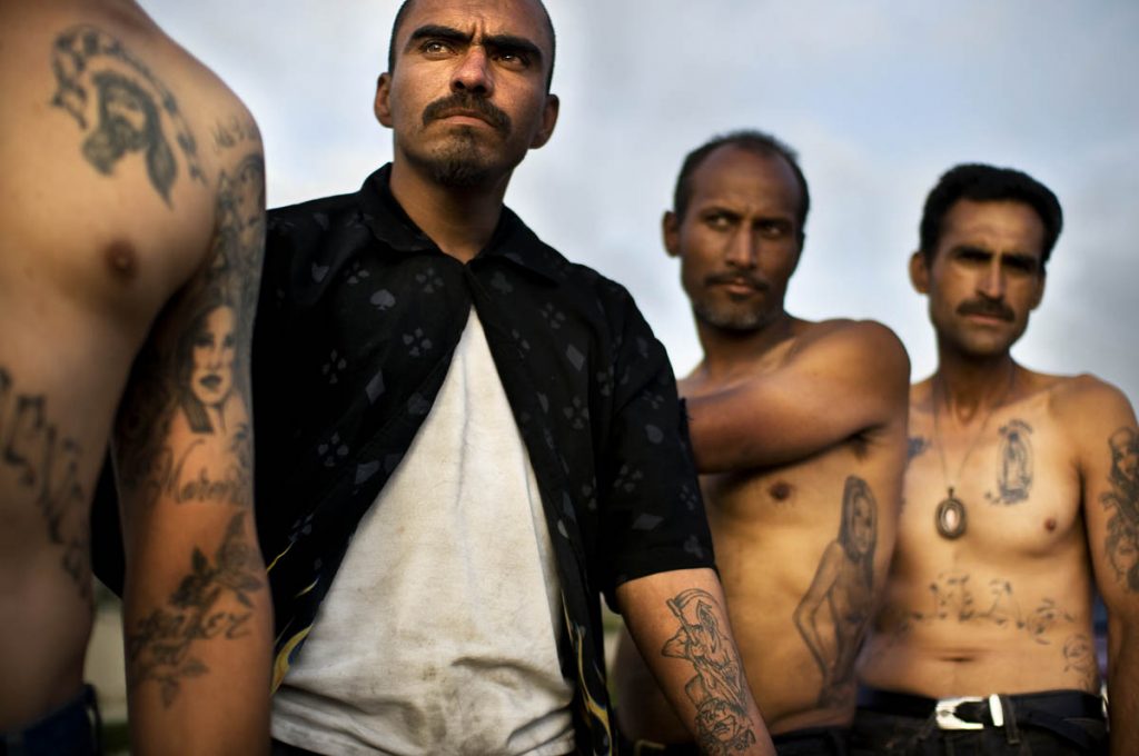 TIJUANA, BAJA CALIFORNIA, MX - JUNE 10 , 2009: Junkies with a tattoos, some of La Santa Muerte, hanging out on the ridge of the Rio Grande River basin on the the Tijuana side of the San Diego border region. It is common to see junkies in "picaderos," or shooting galleries, shooting heroin along the border separating Mexico and the U.S., uninterrupted by nearby border patrol agents or Mexican police. Tijuana, a city of 1.3 million, has the highest prevalence of drug use in Mexico. The more than 2,000 mile border separating Mexico and the U.S forms the most extensive land frontier separating a developed and developing country. (Photo by Shaul Schwarz Reportage by Getty Images for National Geographic)